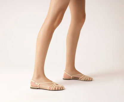 Flat sandal with braided straps, white teardrop shape.