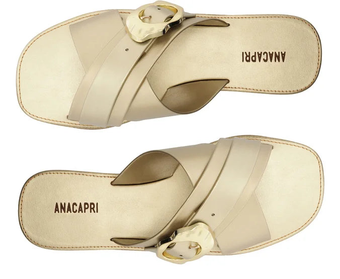 Flat sandal with crossed straps and gold buckle.