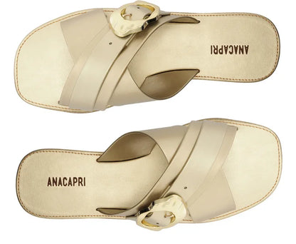 Flat sandal with crossed straps and gold buckle.